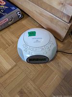 Front view showing display, speakers, attached cord