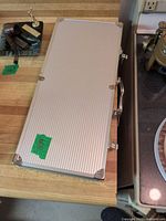 Closed aluminum carry case with handle and latches on countertop