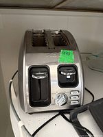 Front view of T-fal toaster showing slots, control panel, brand marking, and function buttons