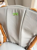 Close-up of grey leather padded backrest with lot sticker