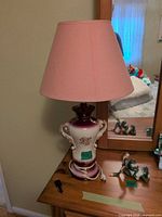 Full view of lamp with shade on wooden dresser