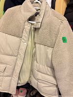 Overall view of Weekend Vibes beige puffer jacket on hanger displaying front, faux shearling panel, pockets, and closure