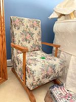 Front side view of floral upholstered child chair showing wood arms and base