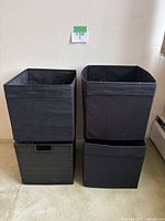 front view showing all four bins stacked, three fabric cubes and one plastic wicker cube