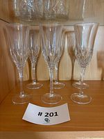 Six matching crystal champagne flutes on shelf