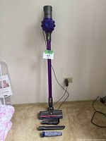 Full view of vacuum on dock with floor head, wand, charger, spare filter