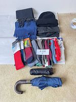 Group shot showing scarves, beanie, gloves, multiple sock packages, two umbrellas