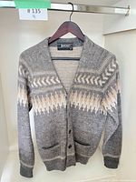 Front view of grey wool cardigan on hanger