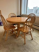 Round oak dining table with four matching chairs