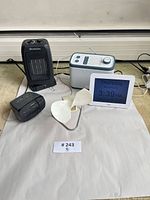 Group shot of all five electronics: heater, Sony clock radio, Relish radio, Robin day clock, desk fan