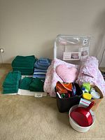Full lot showing towels, comforter set, bins and cleaning items