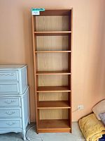 Full front view of tall oak-look bookcase with five shelves