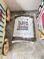 Grey 25 L Black Earth Topsoil bag on concrete floor