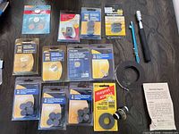 Entire lot laid out: ten magnet packs, battery pack, pickup tool, demagnetizer tool, tape roll, leaflet