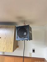 Front view of ceiling-mounted Dyna-Glo heater showing grille and power cord