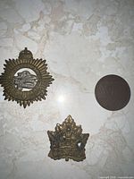 All three metal pieces side by side on light surface