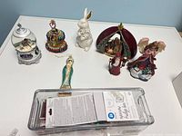 Group shot of all seven figurines and ornament on table