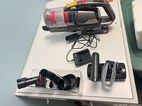 Vacuum body, charger, extension wand, motorized floor head, battery, crevice tool, dusting brush