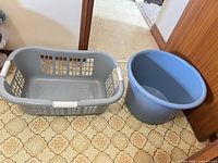 Gray and blue plastic laundry baskets side by side