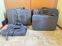 Front view of all four gray luggage pieces