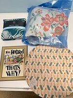 All four items laid out: packaged tablecloth, three placemats (top placemat visible)