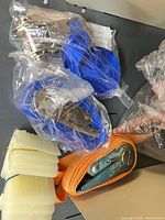 Blue straps in plastic with ratchet hardware and orange strap visible