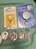 Two packaged key reels and three loose metal reels