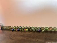 Row of assorted small glass marbles on wooden surface