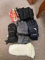 Lot overview showing three pairs of handwear, scarf and hand warmers