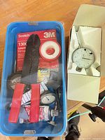 Overview of blue tray with pliers, tapes, small parts, boxed dial indicator alongside