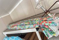 Folded floral patio umbrella on shelf