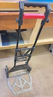 Full front view of folded-out Pack-n-Roll hand truck showing telescoping handle and toe plate