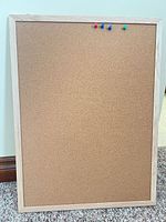 Front view of cork bulletin board with push pins inserted