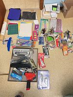 Wide shot showing full assortment of office supplies spread on floor