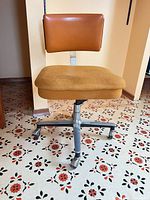 Front view showing vinyl backrest, fabric seat, metal base with casters