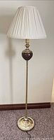 Full view of brass and wood floor lamp with pleated shade