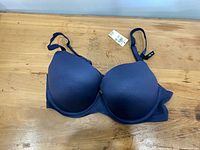 Front view of navy blue Aerie demi bra with tag visible