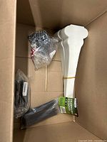 Overview of box with zip ties, small screw bag, white foam supports