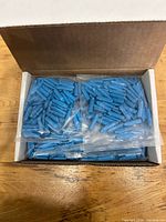 Open box showing multiple bags of blue connectors