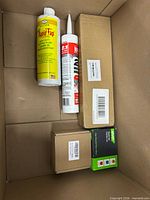 Overall contents inside shipping box showing Rapid Tap bottle, LePage cartridge, two sealed boxes and small green/black retail box