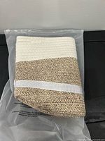 Unpacked basket showing white upper band and brown jute weave, folded flat