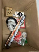 Top view of box showing rolled sheets, keychain tape measure, small boxes, decorative cord