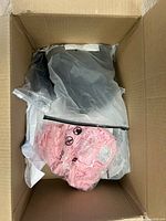 Box containing black, pink garments in plastic