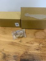 Two product boxes with one gold curtain ring in plastic bag displayed