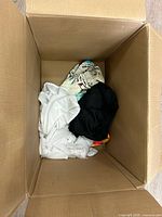 Open box showing loose white, black and printed garments