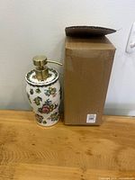 Soap dispenser standing next to original box