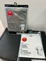 Front view of both sealed Aggressor t-shirts showing colours and packaging