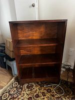 Front view of small wooden bookshelf with three shelves