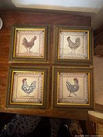 All four framed chicken prints arranged on table