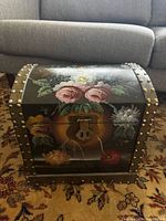 Front view of floral painted wooden dome-top box with latch